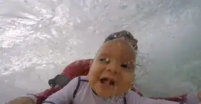 Vídeo mostra bebê de 9 meses surfando com o pai