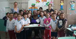 Senhora de 65 anos é acolhida por crianças para aprender a ler