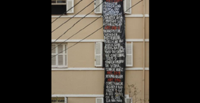 Mulher é fotografada nua por vizinhos e protesta da janela com faixa