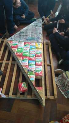 Caixas de leite sendo colocadas no suporte de madeira