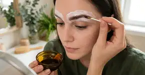Molhe as sobrancelhas com água e aplique com um algodão. Elas ficarão naturalmente mais escuras em até dois tons, sem o uso de henna. Uma maneira de escurecer as sobrancelhas