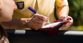 Motorista é multada por dirigir segurando coxinha e sachê de maionese