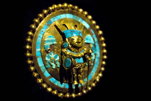 Orejera decorada con oro repujado y detalles de turquesa en el Museo Tumbas Reales de Sipán.