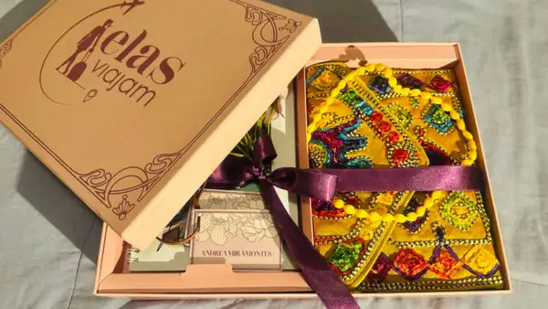 Caixa do Elas Viajam com o livro de viagem e presentes para as mulheres viajantes 