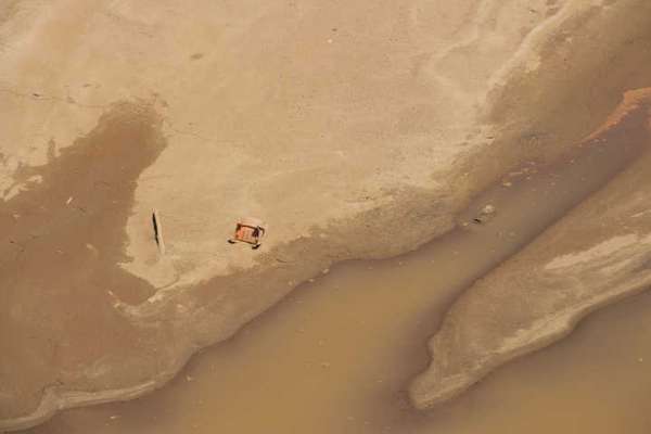 Os 34 milhões de metros cúbicos de rejeitos lançados no meio ambiente pela Samarco* deixaram um rastro de destruição por onde passaram. A cadeira tombada à beira do rio é o retrato de que nada ficou no lugar após a passagem da lama. *Segundo laudo técnico do Ibama publicado em novembro de 2015