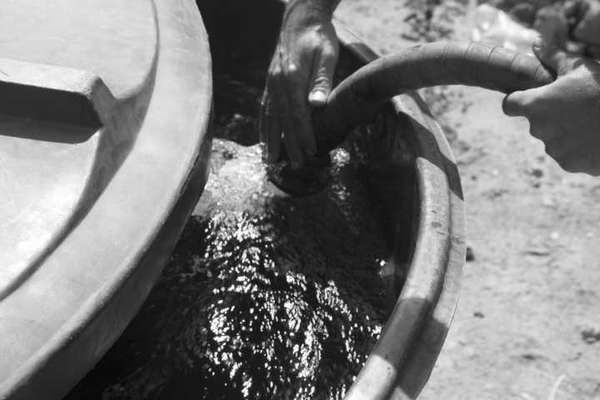 Além do forte cheiro de cloro, a comunidade denuncia a coloração esverdeada da água fornecida pela Samarco. Na imagem, motorista do caminhão-pipa enche caixa d’água na casa de uma família Krenak – cenas como esta acontecem diariamente na aldeia