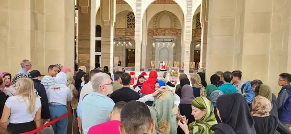 Visitantes estrangeiros aguardam fim da reza para entrarem na mesquita