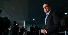 Prefeito Doria joga no chão flores que recebeu de uma ciclista