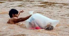 Crianças cruzam rio em saco plástico para chegar a escola no Vietnã