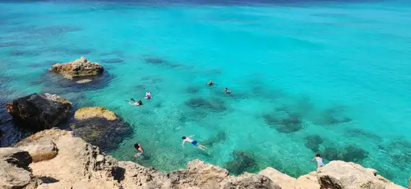 Turistas fazem snorkeling na praia de Kenepa Grandi