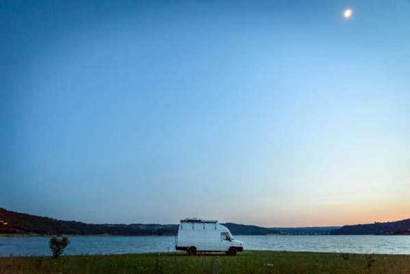 A van com sofá, que também serve como cama, fogão, pia, prateleiras, rede e até mesmo um chuveiro