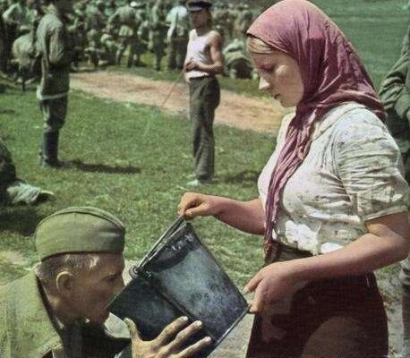 Um soldado soviético bebe água oferecida por uma mulher ucraniana após ser capturado. [1941]