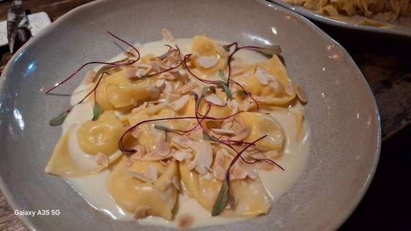 Torteli brie com damasco, molho branco e amêndoas laminadas